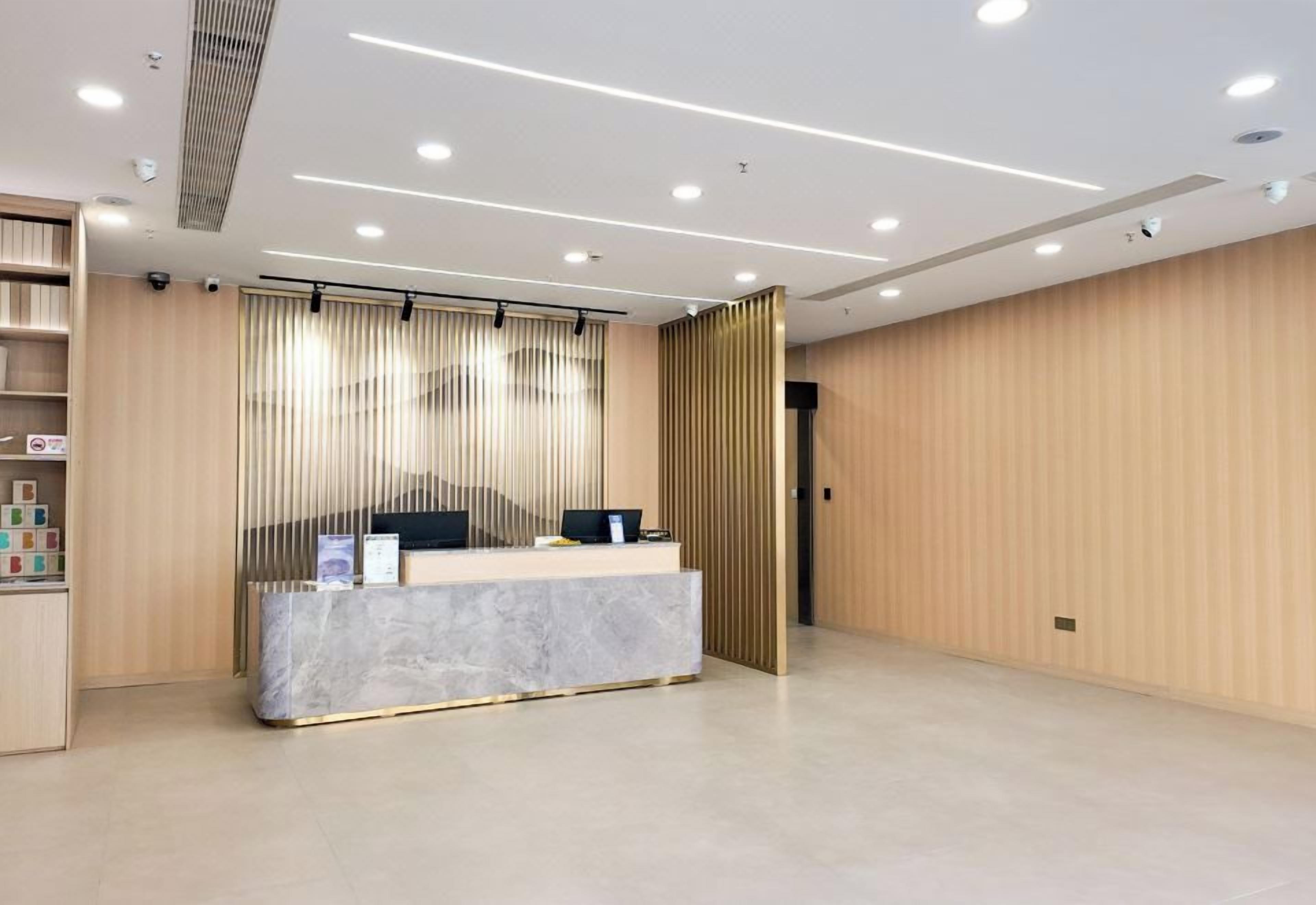A reception area with a marble counter, a security camera, and a wooden panel wall.