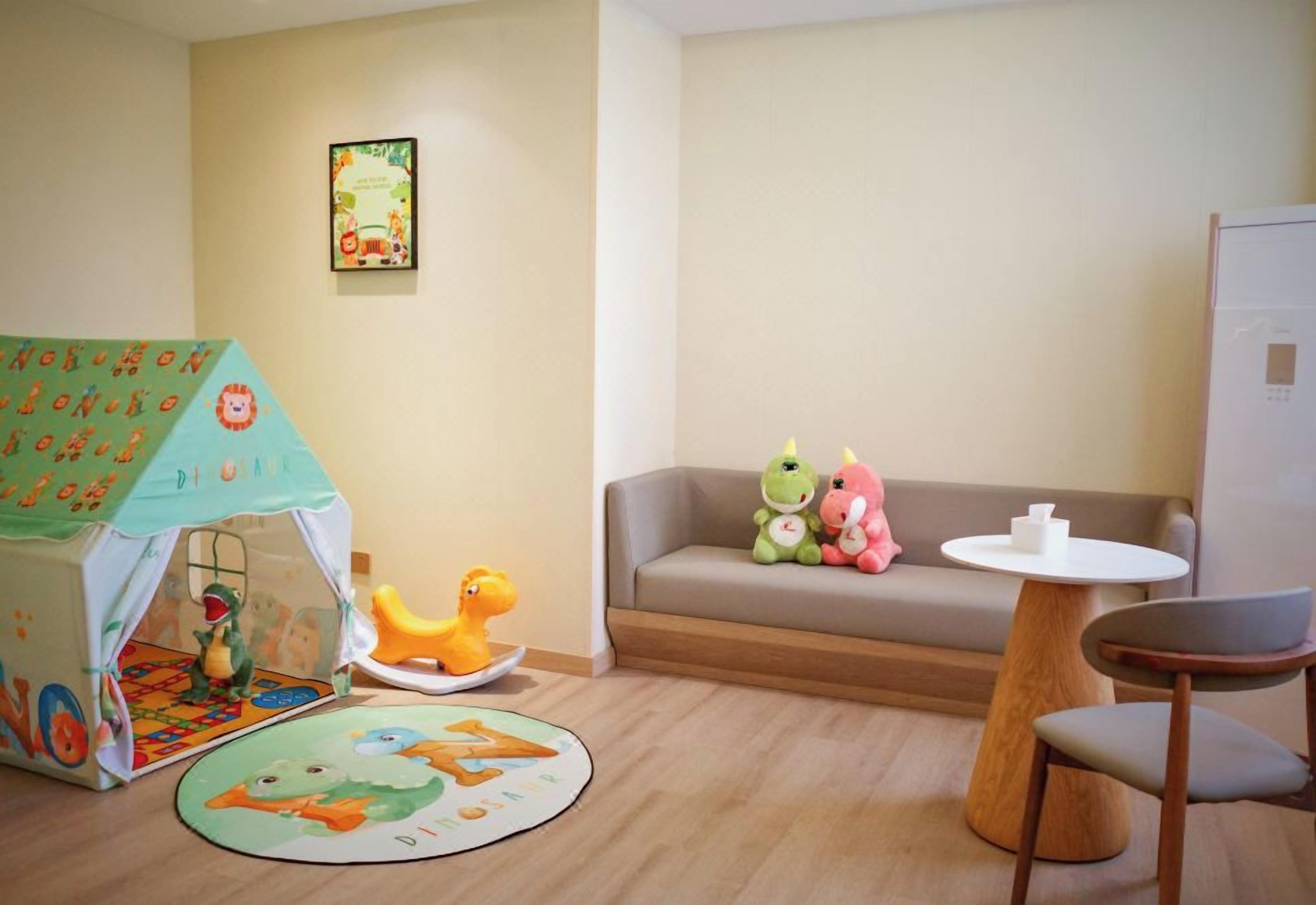 A child's play area with a tent, toys, and a sofa.