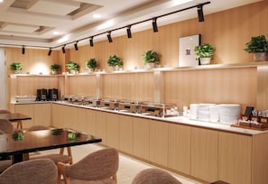 A modern kitchen area with a long counter, multiple coffee machines, and a variety of kitchen appliances. - Joyful Star Hotel (Shanghai)
