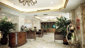 A spacious lobby with marble flooring, wooden furniture, and potted plants. - Tianjin International Hotel (Hotan City)