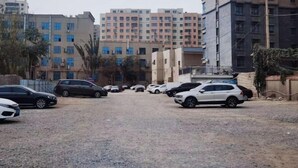 A parking lot with several cars, surrounded by multi-story residential buildings. - Tianjin International Hotel (Hotan City)
