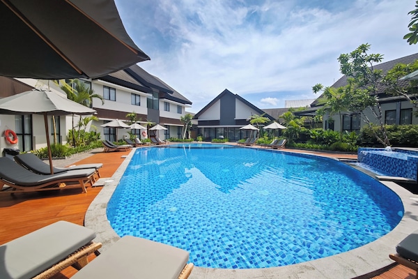 Alberca al aire libre, sombrillas en la alberca y camastros