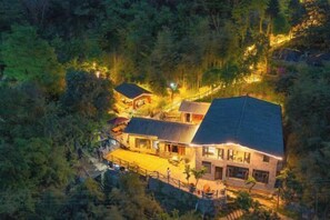 A multi-story building with a sloped roof, surrounded by dense forest. - Wudangshan Taiziju Inn (Danjiangkou)