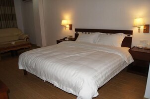 Una cama bien hecha con sábanas blancas en una habitación de hotel.