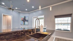 A kitchen with a marble countertop, a modern faucet, pendant lights, and a large window. - 7 min to the Beach. Family Venice Beach Retreat. Private Saltwater Screened Pool (Venice)
