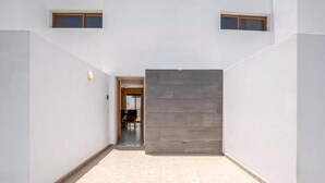 A spacious, well-lit hallway with a neutral color palette, leading to a door and a small window. - House - Sleeps 4 & Swimming Pool (Tias)