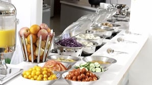 A buffet with various food items including fruits, vegetables, and meat dishes. - Dongguan Qingxi E Hotel (Dongguan)