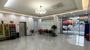 A hotel lobby with a chandelier, a reception desk, a seating area, and a vending machine. - Dongguan Qingxi E Hotel (Dongguan)