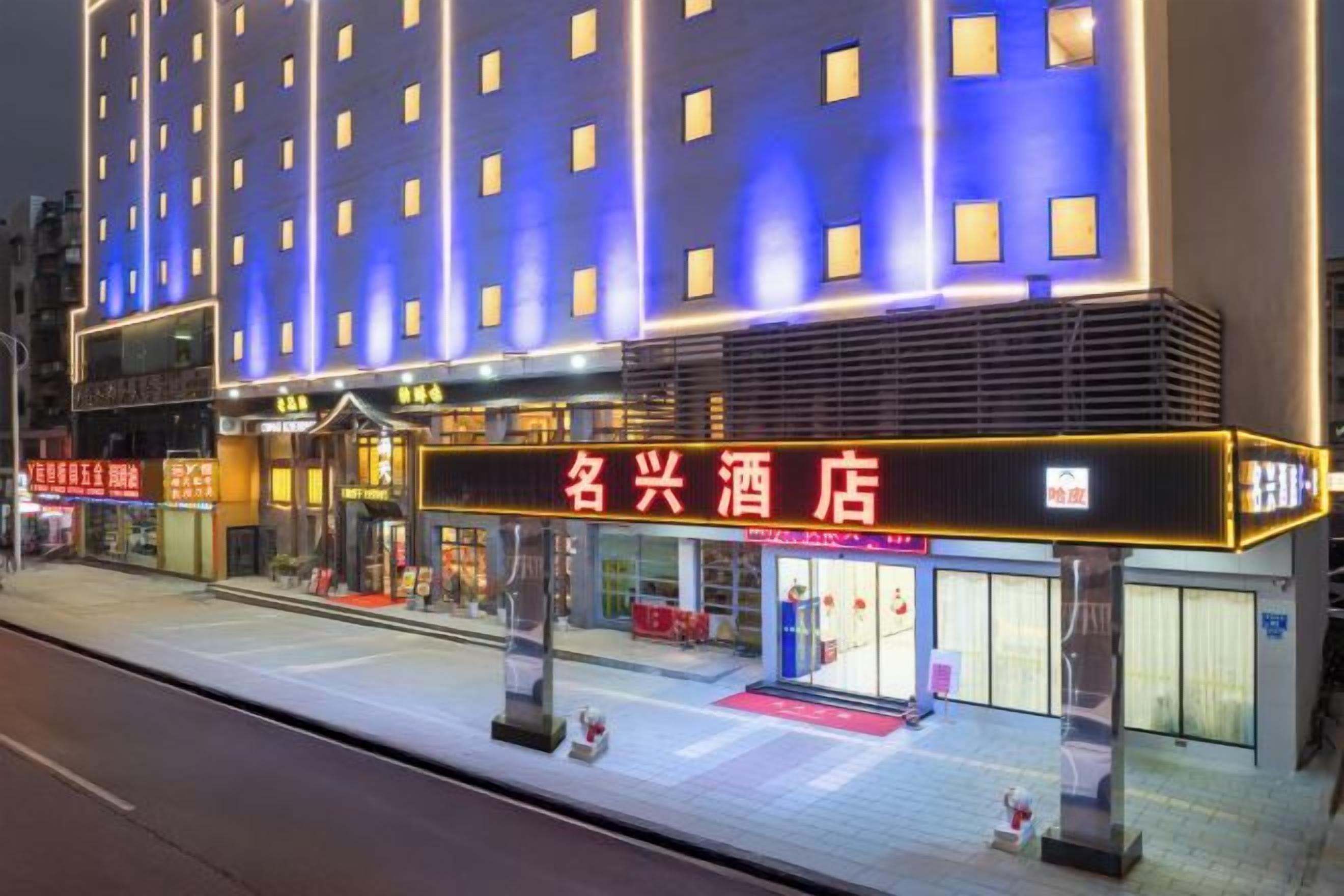 A hotel with a prominent sign, multiple floors, and a covered entrance area.
