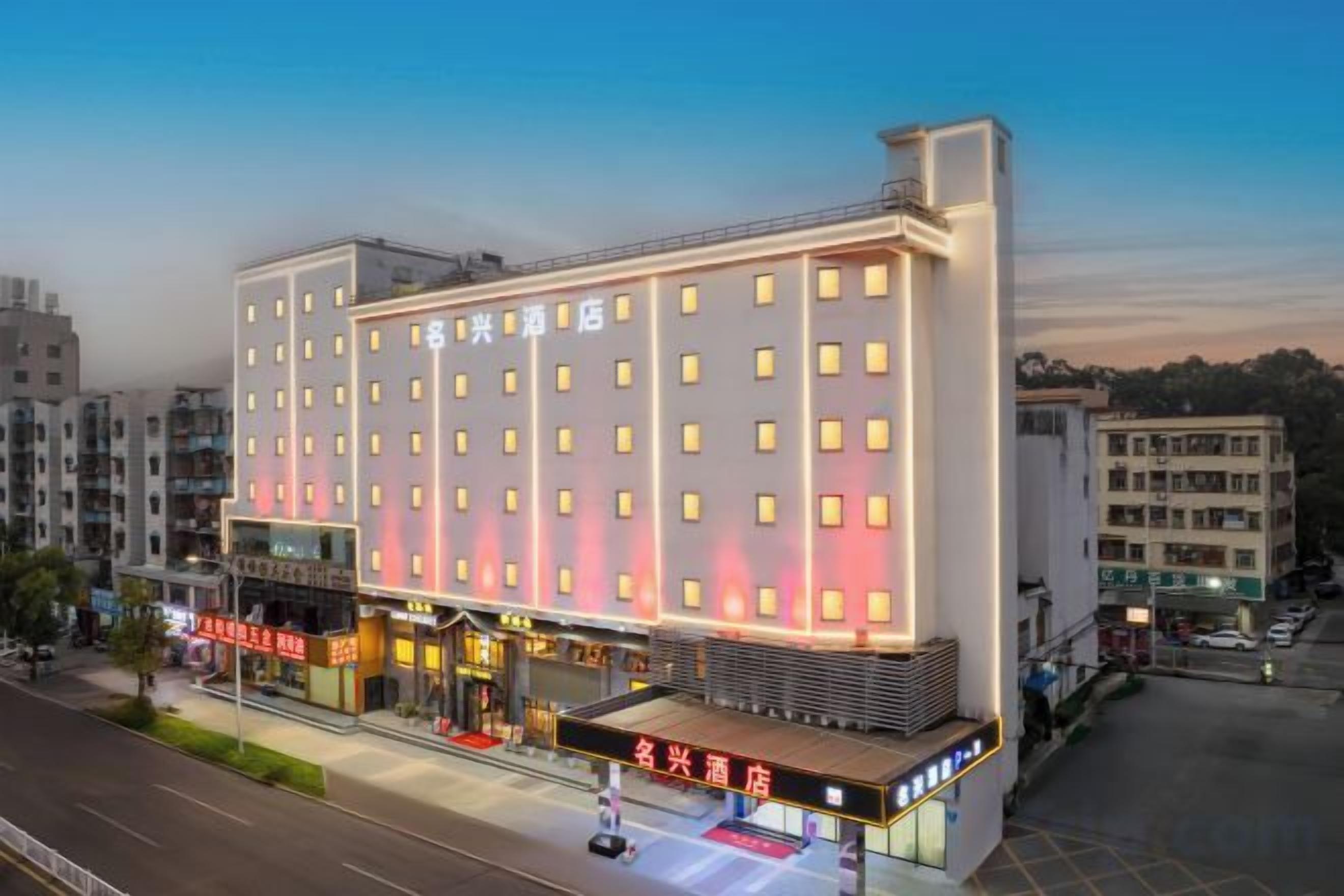 A multi-story hotel with a modern facade, multiple balconies, and a ground-level commercial area.