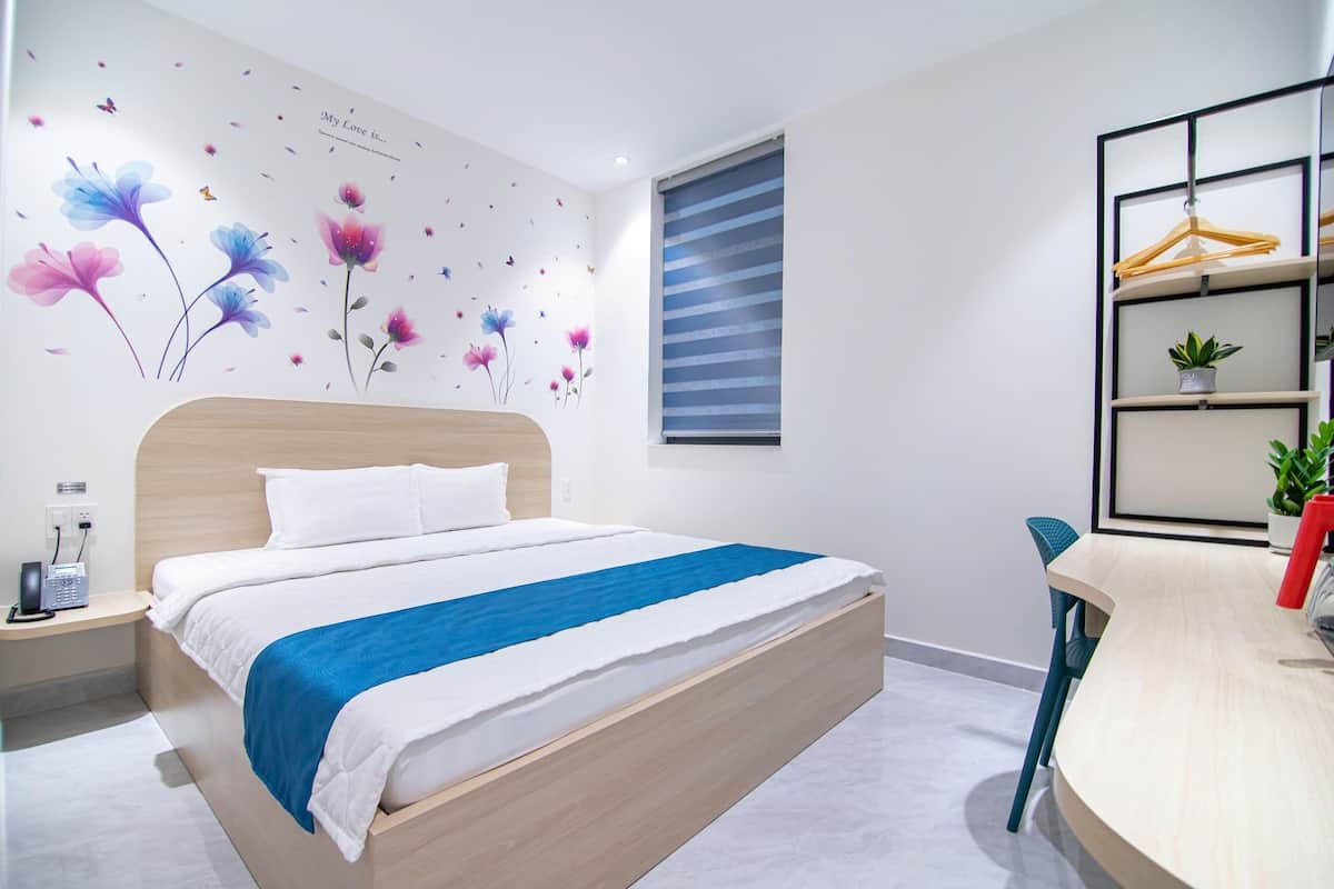 Ein modernes Schlafzimmer mit einem Bett, einem Nachttisch, einem Schreibtisch und einem Stuhl.