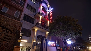 A hotel entrance with a prominent neon sign, a gated entrance, and potted plants. - Bin Bin Hotel 14 - Near Vstar School D7 (Ho Chi Minh City)
