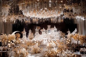 Un escenario con fondo blanco, luces de hadas y una decoración que representa un pueblo.