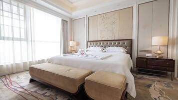 Habitación de hotel con una cama grande, una mesita de noche y un amplio ventanal.