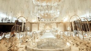 A wedding venue with a central aisle, floral decorations, and a chandelier. - Fairyland International Hotel (Xiantao)