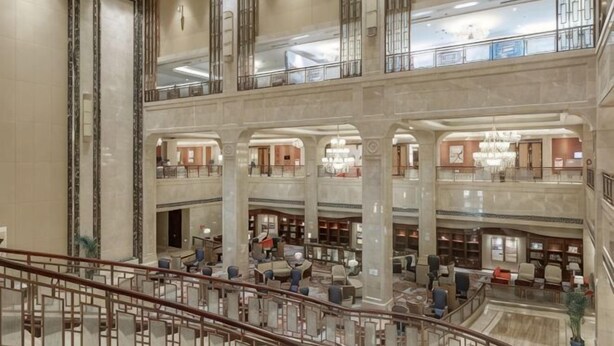 A multi-level hotel lobby with marble columns, a grand staircase, and a chandelier. - Fairyland International Hotel (Xiantao)