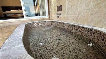Enjoy a relaxing soak in the bathtub, surrounded by a spacious bathroom with a large glass door leading to an outdoor area.