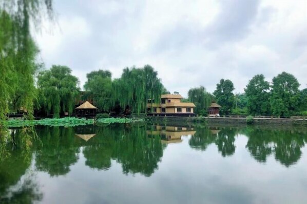 A serene lakeside setting with a house and a gazebo.