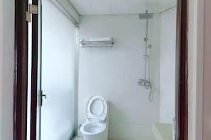 Ein Badezimmer mit Toilette, Dusche und Handtuchhalter.