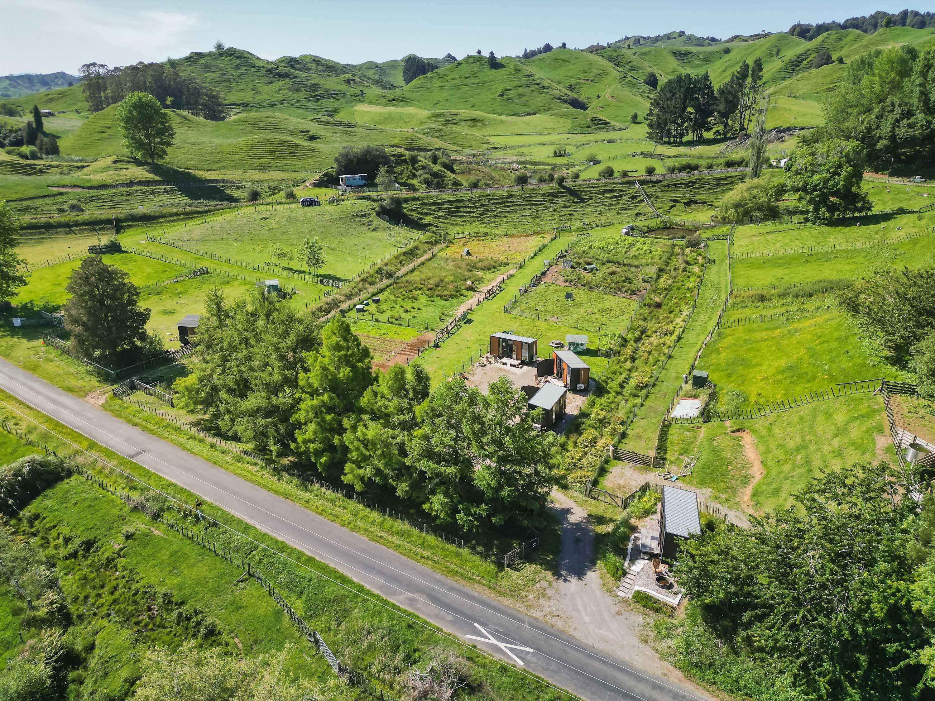 A rural landscape with terraced fields, a road, and scattered buildings.