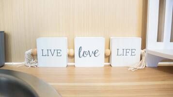 Tres bloques blancos con las palabras 'LIVE', 'love' y 'LIFE', dispuestos sobre una superficie de madera.
