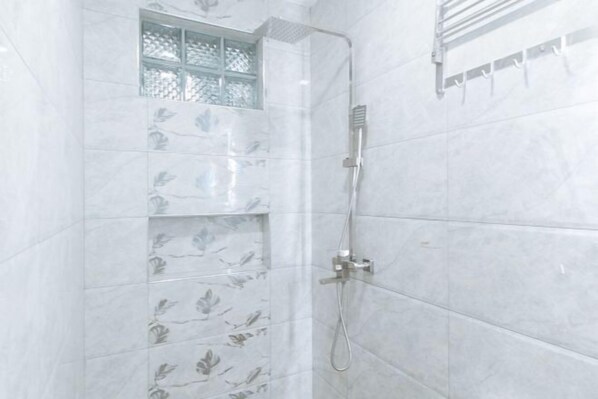 A shower with a handheld showerhead and a wall-mounted towel rack. - RedDoorz Plus @ Bez Tower and Residences San Juan (San Juan)