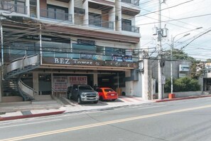 Un edificio con un letrero que dice 'BEZ Travel & Hotel' y una escalera que lleva a un nivel superior.