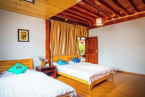 Une chambre avec deux lits en bois, une table de chevet, une lampe fixée au mur et une fenêtre avec des rideaux.
