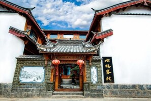A traditional building with a tiled roof, wooden beams, and a staircase leading to the entrance.