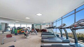 Un gimnasio moderno con cintas de correr, máquinas de pesas y una zona de levantamiento de pesas.