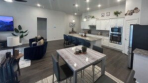 A modern kitchen with white cabinets, a central island, and built-in appliances.