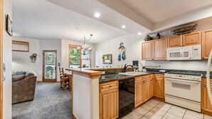 A modern kitchen with wooden cabinets, a built-in oven, and a microwave. - Breckenridge Condo with Hot Tub Access (Breckenridge)