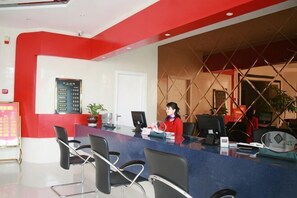 A reception desk with a receptionist, a computer, and a plant. - Fuerte Hotel Leqing Haian (Yueqing)