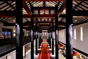 A corridor with a red carpet, wooden beams, and columns. - Fuzhou Guian Xishan Hot Spring Resort (Lianjiang)