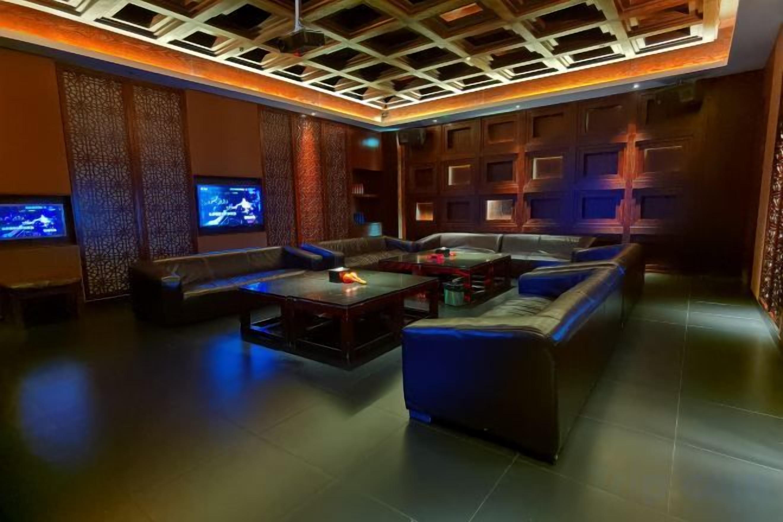 A modern lounge area with a sofa, a coffee table, and a flat-screen TV.