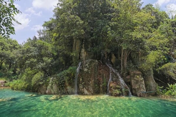 Une formation rocheuse naturelle avec une cascade et de l’eau claire.