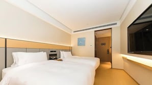 A hotel room with a large bed, a bedside table, a nightstand, a window, and a door leading to another room. - JI Hotel (Hangzhou Binjiang University of Chinese Medicine Subway Station) (Hangzhou)
