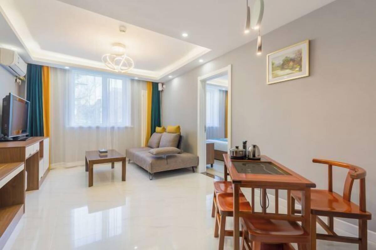 A modern living room with a sofa, a coffee table, and a dining table with chairs.