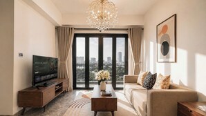 A modern living room with a large window, a television, a sofa, and a coffee table.