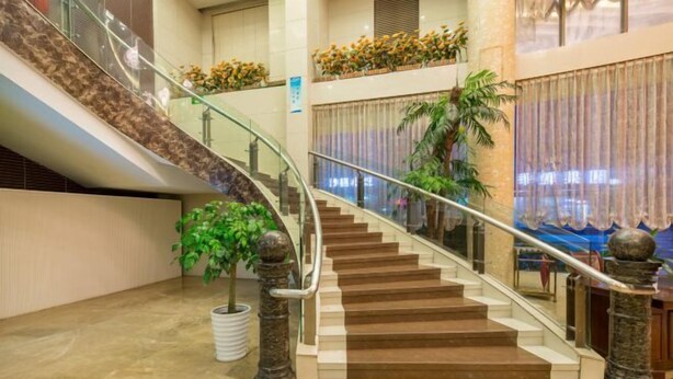 Eine imposante Treppe mit Glastrennwand, die zu einer oberen Etage führt.