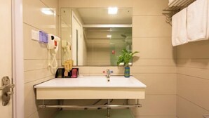 A bathroom with a white sink, a mirror, a towel rack, a plant, and a hand dryer. - Hengdian World Studios Hengpiao Grand Hotel (Dongyang)