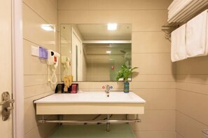 A bathroom with a white sink, a mirror, a towel rack, a plant, and a hand dryer. - Hengdian World Studios Hengpiao Grand Hotel (Dongyang)