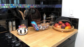 Eine Küchenarbeitsplatte mit einer Kaffeemaschine, einer Obstschale und einer Kaffeemühle.