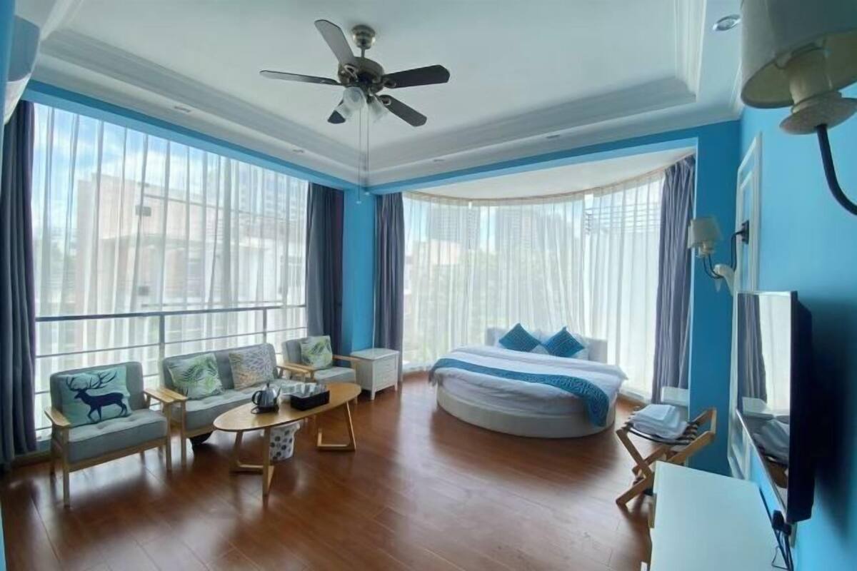 Ein Hotelzimmer mit einem großen Bett, einer Couch, einem Couchtisch und einem Fernseher.