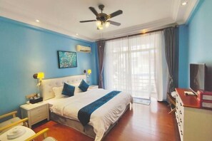 A hotel room with a large bed, a ceiling fan, a TV, and a window with curtains. - Jinse Gangwan sea veiw Villa (Dongshan County)