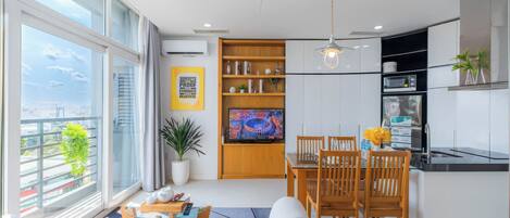 A modern kitchen with a dining area, large windows, and a view of the city.