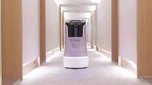 A hallway with a modern, minimalist design, featuring a central column with a logo and text, and a clean, geometric floor pattern. - JI Hotel (Chengdu Global Center) (Chengdu)