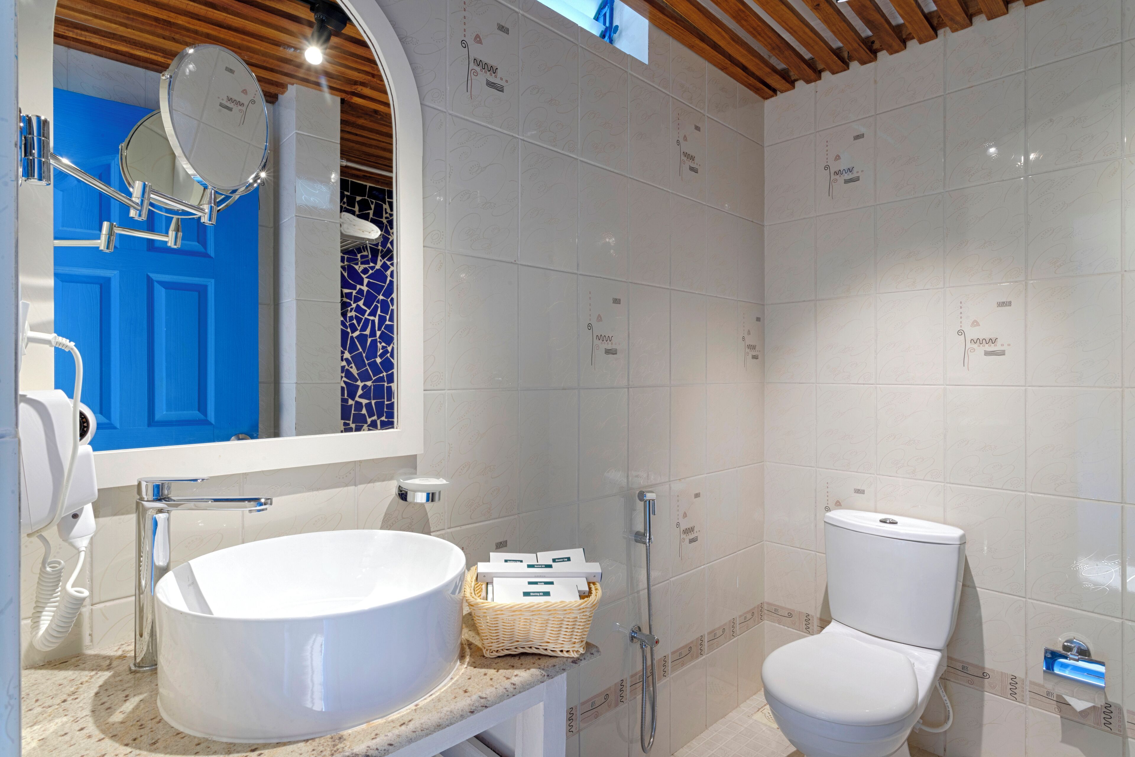 Un baño con un lavabo blanco, una puerta azul y un inodoro blanco.
