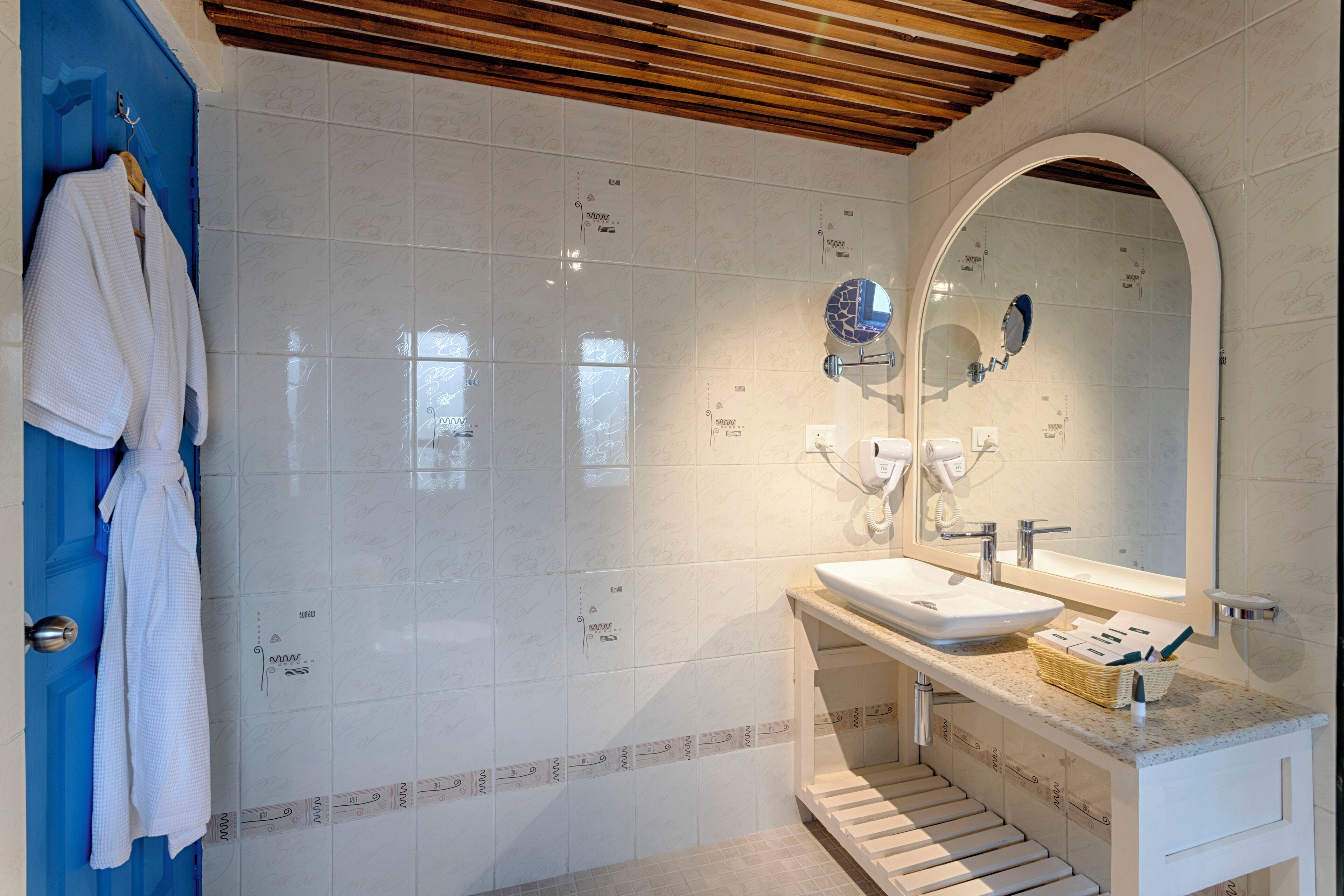 A bathroom with a white sink, mirror, and towel rack.
