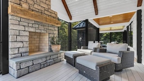 A covered outdoor seating area with stone fireplace, wicker furniture, and a view of the outdoors. - Luxury Escape, Hot Tub, Fireplace, Espresso Bar (Ickesburg)